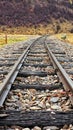 Vertical shot of an a metal railway tracks in toward mountain Royalty Free Stock Photo