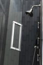 Vertical shot of a metal shower in the bathroom attached to a wall Royalty Free Stock Photo