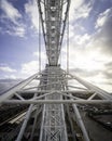 Vertical shot of a metallic construction part of Ferris wheel on a cloudy blue sky background