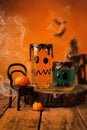 Vertical shot of a miniature chair with pumpkins and glasses of juice on a wooden ground.