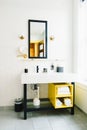 Vertical shot of a minimal modern bathroom with a bold design and yellow accents