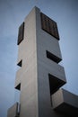 Vertical shot of a modern interesting building with balconies on the blue sky background