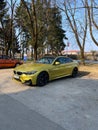 Vertical shot of a modern yellow BMW M4 parked in a parking lot