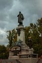 Vertical shot of Monument of Adam Mickiewicz against gray clouds