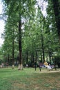 Vertical shot of the mother with her child sitting on the swing in the summer park. Suzhou, China.