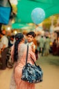 Vertical shot of a mother holding her little son with a balloon in the streets of Nathdwara, India