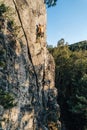 Vertical shot of a mountain climber climbing the rocks using his climbing equipment