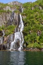 Multi-stream waterfall cascading into Trollfjorden, surrounded by lush greenery Royalty Free Stock Photo