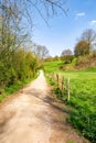 Vertical shot narrow path in the countryside surrounded by green valley