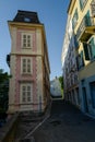 Vertical shot of a Narrow Street with pink building with yellow shutters windows, downtown Lausanne