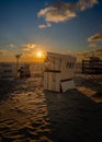 Vertical shot of a numbered Basket chairs on the beach at sunset Royalty Free Stock Photo