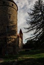 Vertical shot of the Nunna de Tagune tower in Estonia with a tree and a cloudy sky in the background