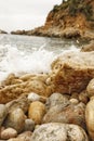 Vertical shot of ocean waves crashing into rocky shoreline