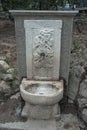 Vertical shot of an old ancient stone-made fountain with a faucet in Athens, Greece Royalty Free Stock Photo