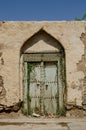 Vertical shot of an old beautiful and ornamented front door  with a climbing plant growing on top Royalty Free Stock Photo