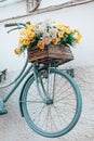 Vertical shot of an old bicycle painted blue, serving as a stand for the wooden box of flowers Royalty Free Stock Photo