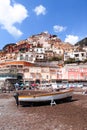 Vertical shot of an old boat on the beach of Positano with colourful houses on the background Royalty Free Stock Photo