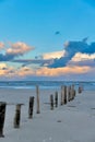 Vertical shot of an Old breakwaters on the North Sea beach during sunset Royalty Free Stock Photo