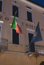 Vertical shot of an old building with the Italian flag on the balcony in Lazise, Italy