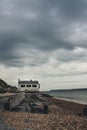 Vertical shot of an old coastguard watchhouse under a cloudy sky at Lepe Beach, Hampshire, UK.