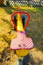 Vertical shot of an old colorful seesaw in a playground during daytime