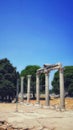 Vertical shot of old columns in the middle of a field Royalty Free Stock Photo