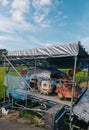 Vertical shot of an old combine harvester machine on a galvanized steel pegboard under a covering