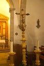 Vertical shot of old crucifix and candles inside the church Royalty Free Stock Photo