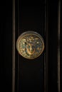 Vertical shot of an old door knob with female head design on Georgian black front door.