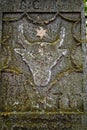 Vertical shot of an old gravestone with a bull skull and star engraved on it