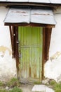 Vertical shot of an old green door with a metal roof Royalty Free Stock Photo