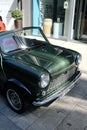 Vertical shot of an old green Mini Cooper parking in the city center of Hamburg