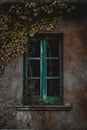 Vertical shot of an old green window of an abandoned building in a ghost town Royalty Free Stock Photo