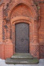 Vertical shot of an old mysterious building with a metal door Royalty Free Stock Photo