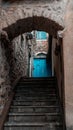 Vertical shot of an old narrow stone staircase leading to the entrance door of the building Royalty Free Stock Photo