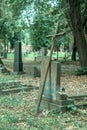 Vertical shot of an old rusted cross with a spider web on it in the cemetery