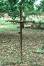 Vertical shot of an old rusted cross with a spider web on it in the cemetery