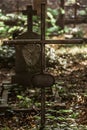 Vertical shot of an old rusted cross with a spider web on it in the cemetery