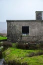 Vertical shot of an old stone barn with animals in the Irish countryside under gray sky Royalty Free Stock Photo