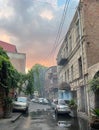 Vertical shot of an old Tbilisi bathhouse with parked cars at sunset, Georgia