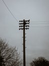 Vertical shot of an old telephone pole on a cloudy day Royalty Free Stock Photo