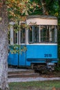 Vertical shot of old tram under trees in autumn