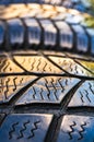 Vertical shot of old used worn car wheel tyres pile stacked in rows