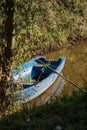 Vertical shot of an old wooden boat on a river in the woods - nostalgic scene