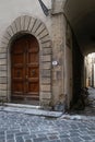 Vertical shot of an old wooden door in an arch frame on the corner of a street, Florence, Italy Royalty Free Stock Photo