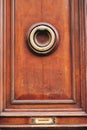 Vertical shot of an old wooden door with an ornate door knocker Royalty Free Stock Photo