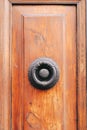 Vertical shot of an old wooden door with an ornate door knocker Royalty Free Stock Photo