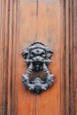 Vertical shot of an old wooden door with an ornate door knocker Royalty Free Stock Photo