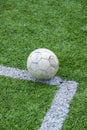 Vertical shot of an old worn-out soccer ball on a field with artificial grass Royalty Free Stock Photo