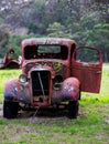 Vertical shot of an old wreck rusted car in a field Royalty Free Stock Photo
